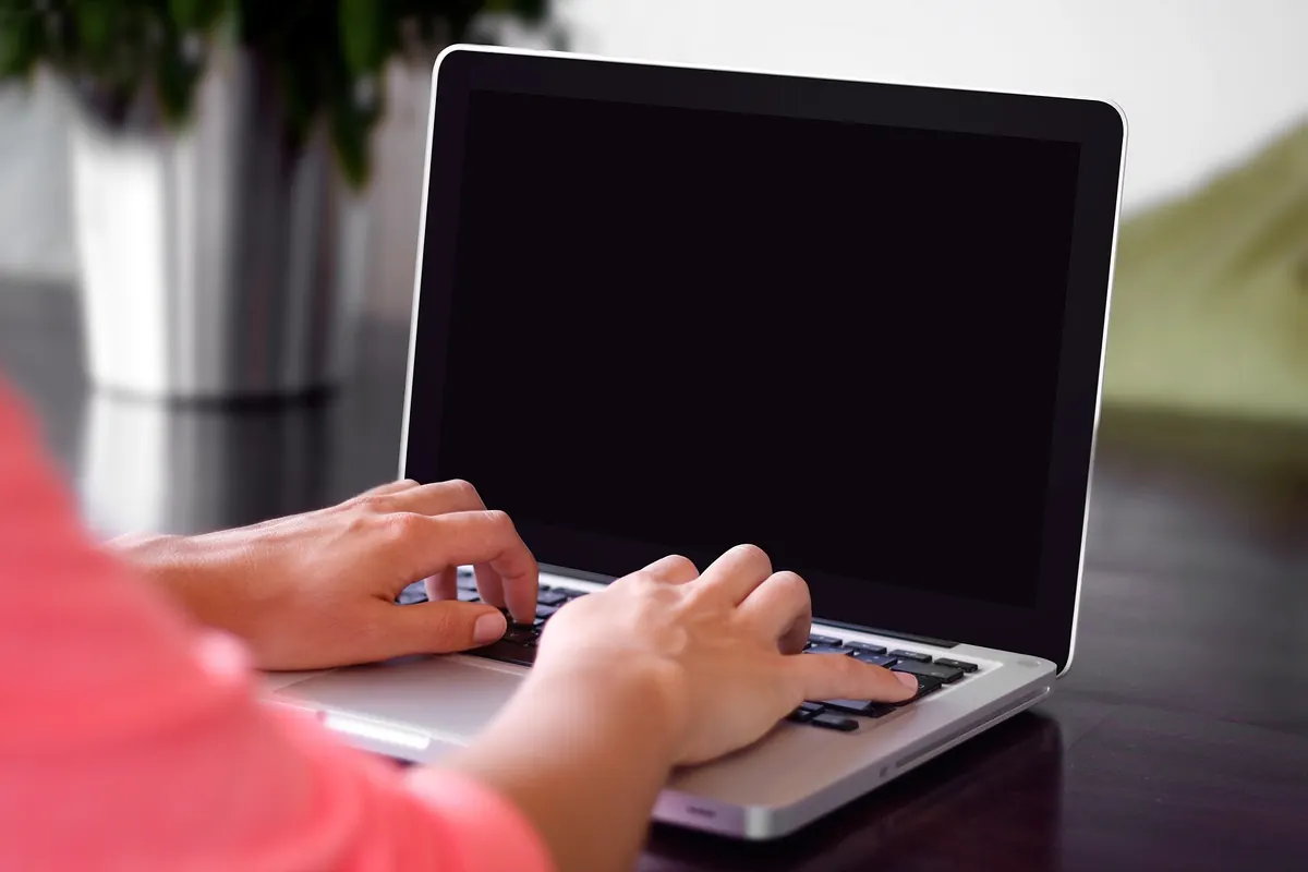 Hands typing on a laptop; the screen shows a sentence with named entities tagged